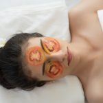 Young woman with fresh tomatoes mask in spa.